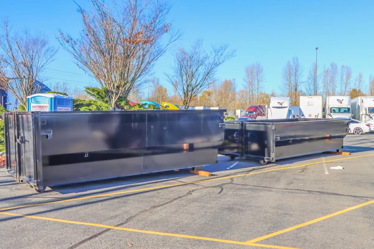 Professional dumpster rental service with roll-off container on residential driveway in Indianola